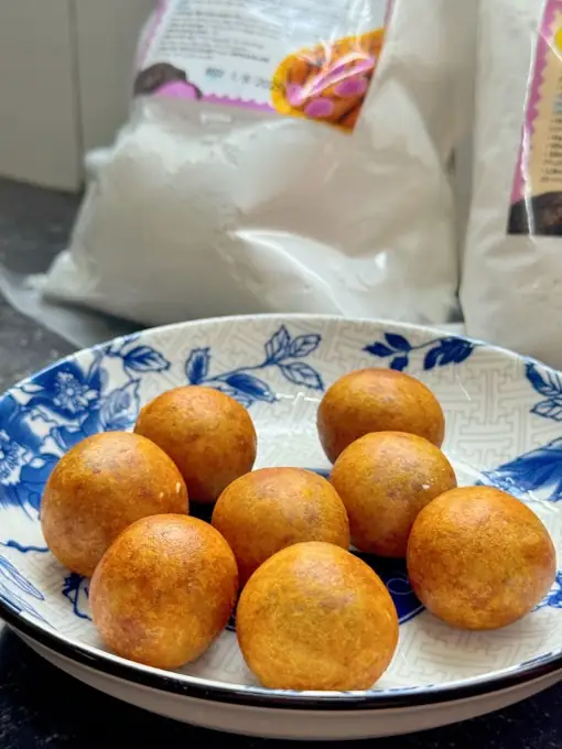 Bánh khoai mỡ chiên tròn vàng bày trên đĩa sứ hoa xanh